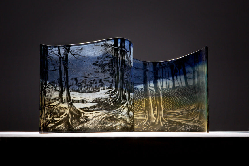 Glass Workshop in Elora showcasing a beautifully painted glass piece with trees and landscape imagery.
